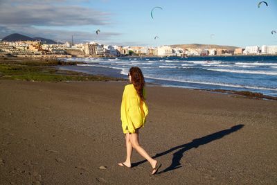 Woman walking at beach during sunny day
