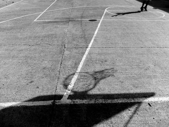 Shadow of basketball hoop on court