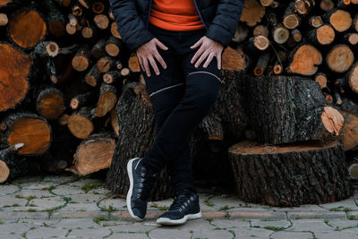 Low section of man sitting on log
