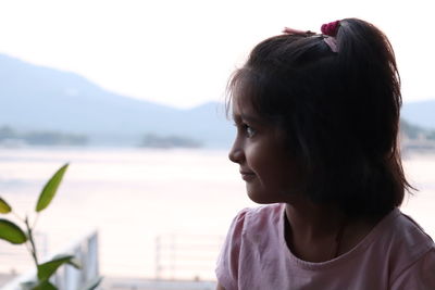 Portrait of woman looking away against sky