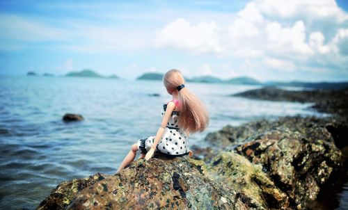 Rear view of man looking at sea against sky