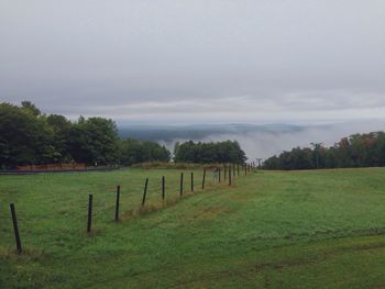 Scenic view of grassy field against cloudy sky