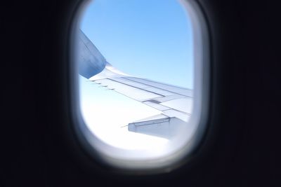 Airplane flying against sky seen through window