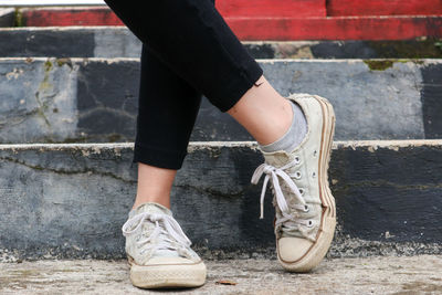 Low section of woman on cobblestone street