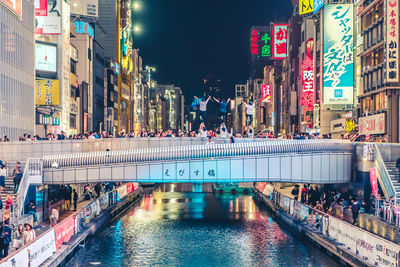 Illuminated street amidst buildings in city at night