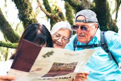 Portrait of smiling friends using digital tablet