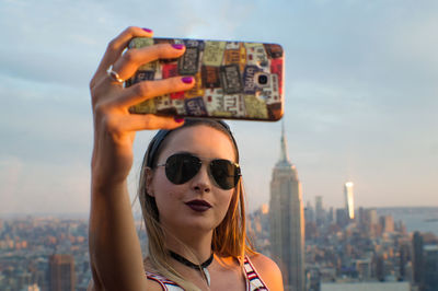 Close-up of woman taking selfie against emperor state building