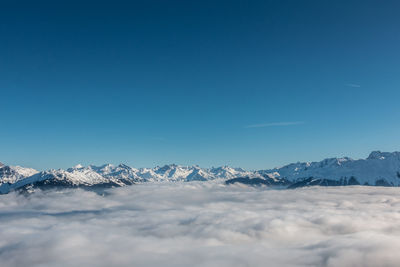 Scenic view of snowcapped mountains against clear blue sky