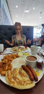 Portrait of young woman having food in restaurant