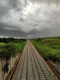 Railroad tracks on field against sky