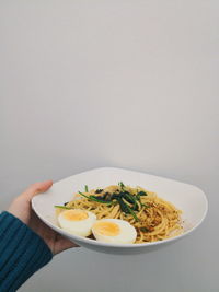 Cropped hand holding food on white background