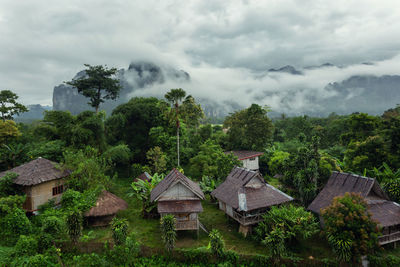Houses amidst trees and buildings against sky