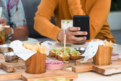 Midsection of man using mobile phone