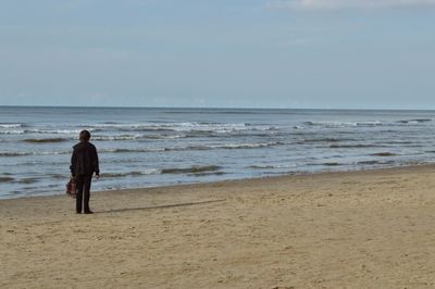 Rear view of a man walking on beach