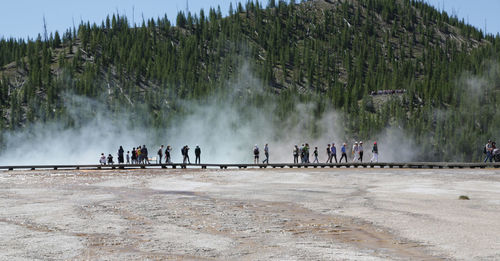 People at yellowstone national park against sky