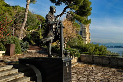 Statue by trees against sky