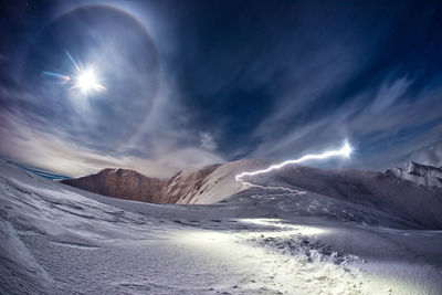 Scenic view of snowcapped mountains against sky at night