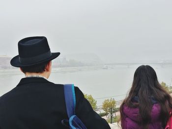 Rear view of couple sitting on sea shore