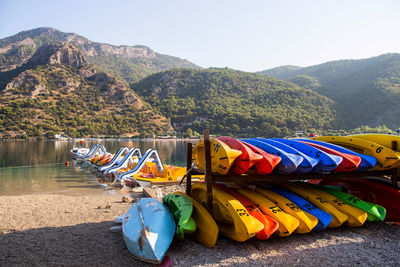 Multi colored boats by sea against mountains 