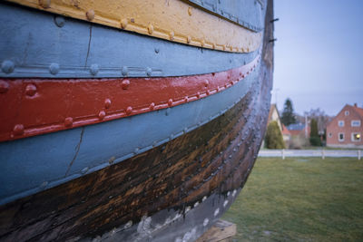 Close-up of old boat moored on land against sky