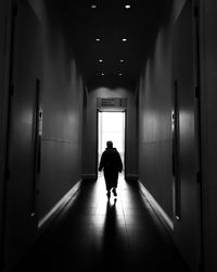 Rear view of woman walking in corridor