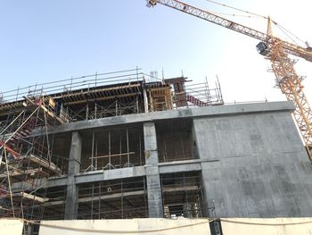 Low angle view of building under construction against clear sky