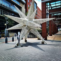 Footpath by buildings on street in city