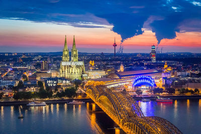 High angle view of illuminated hohenzollern bridge and cologne cathedral at dusk