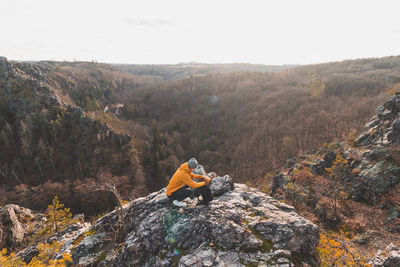 High angle view of man sitting on rock