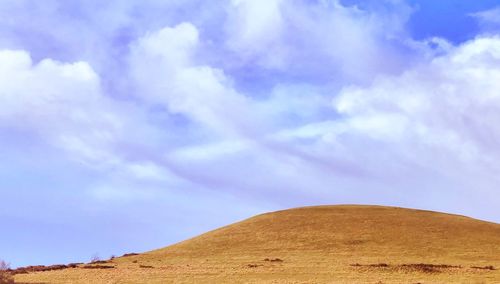 Low angle view of arid landscape against sky