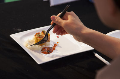 Cropped image of person having food served on table