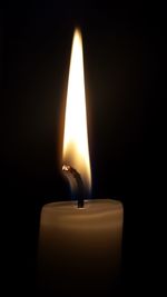 Close-up of illuminated candle against black background