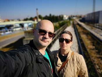 Portrait of couple standing on railroad tracks