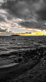 Scenic view of sea against dramatic sky during sunset