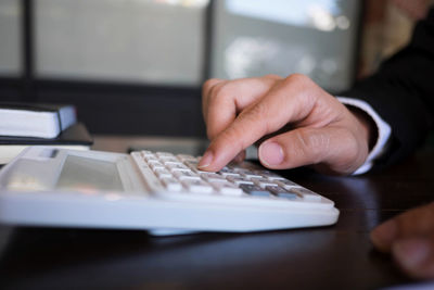 Midsection of man using laptop on table