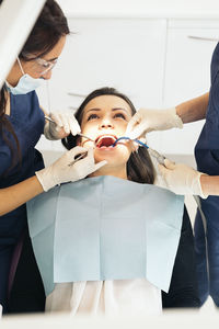 Female dentists examining patient in hospital