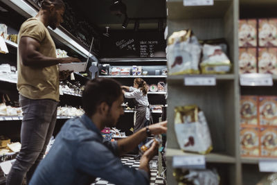 Male and female coworkers working at delicatessen shop