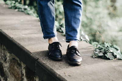 Low section of woman standing on footpath