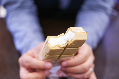 Close-up of cropped hand holding ice cream sandwich