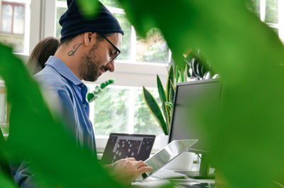 Side view of man using digital tablet in office