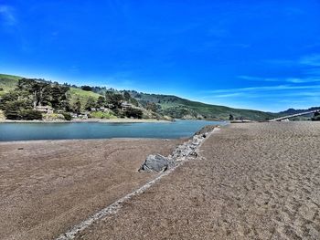 Scenic view of beach against blue sky