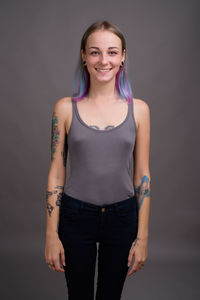 Portrait of a smiling young woman over black background