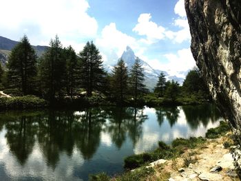 Scenic view of lake by trees against sky