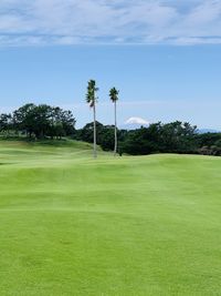 Scenic view of golf course against sky