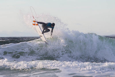 Man surfing on sea against sky