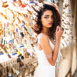 Portrait of young woman standing by padlocks