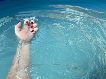 Low section of woman relaxing in swimming pool