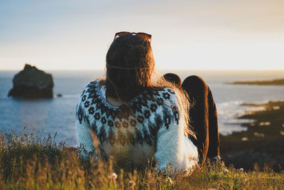 Rear view of woman at beach during sunset