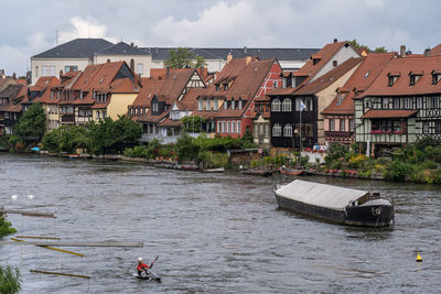 Boat in river by buildings in city