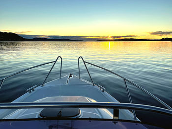 Boat sailing in sea against sky during sunset
